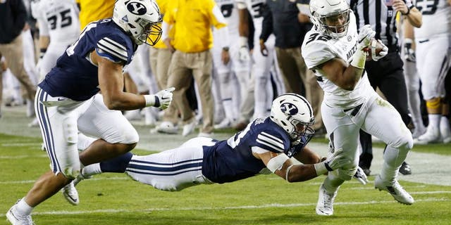 Missouri running back Russell Hansbrough, right, slips past BYU linebackers Jherremya Leuta-Douyere, center, and Harvey Langi, left, in the first half of a college football game at Arrowhead Stadium, Saturday, Nov. 14, 2015, in Kansas City, Mo. (AP Photo/Colin E. Braley)