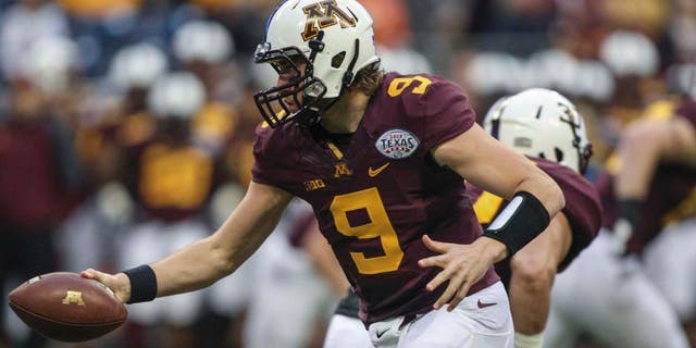Dec 27, 2013; Houston, TX, USA; Minnesota Golden Gophers quarterback Philip Nelson (9) hands the ball off during the first quarter of the Texas Bowl against the Syracuse Orange at Reliant Stadium . Mandatory Credit: Troy Taormina-USA TODAY Sports