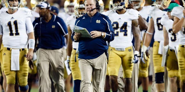 Sep 7, 2013; Ann Arbor, MI, USA; Notre Dame Fighting Irish head coach Brian Kelly (center) leads the team down the field during the timeout between the third and forth quarters against the Michigan Wolverines at Michigan Stadium. Mandatory Credit: Rick Osentoski-USA TODAY Sports