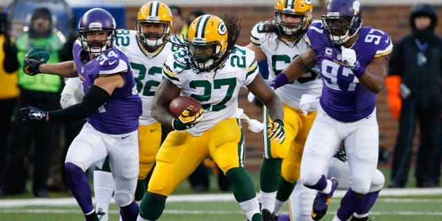 Green Bay Packers running back Eddie Lacy (27) runs past Minnesota Vikings strong safety Andrew Sendejo (34) an defensive end Everson Griffen (97) during the first half of an NFL football game in Minneapolis, Sunday, Nov. 22, 2015.