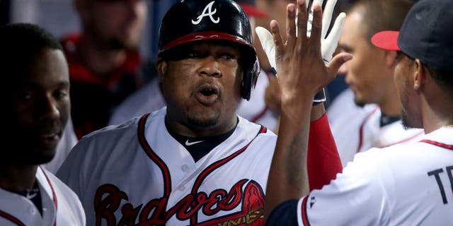 Jul 1, 2015; Atlanta, GA, USA; Atlanta Braves third baseman Juan Uribe (2) celebrates with teammates after hitting a sole home run in the fourth inning of their game against the Washington Nationals at Turner Field. Mandatory Credit: Jason Getz-USA TODAY Sports