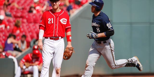 The Milwaukee Brewers' Ryan Braun rounds third after hitting a solo home run as Cincinnati Reds third baseman Todd Frazier looks on in the eighth inning Sunday, Sept. 6, 2015, in Cincinnati.