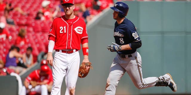 The Milwaukee Brewers' Ryan Braun rounds third after hitting a solo home run as Cincinnati Reds third baseman Todd Frazier looks on in the eighth inning Sunday, Sept. 6, 2015, in Cincinnati.