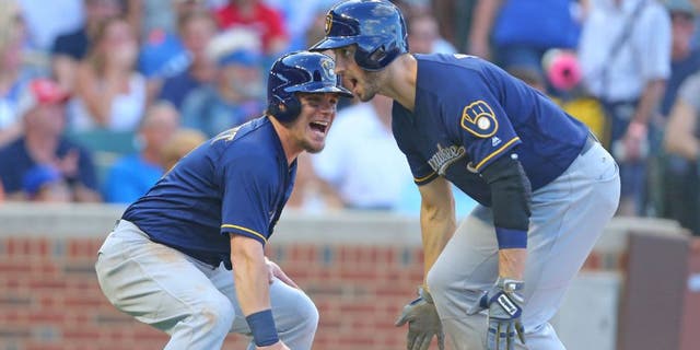 Milwaukee Brewers left fielder Ryan Braun celebrates his two RBI home run with second baseman Scooter Gennett during the sixth inning against the Chicago Cubs.
