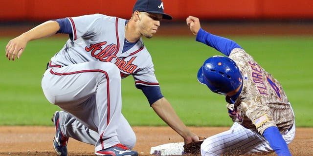 Sep 21, 2015; New York City, NY, USA; Atlanta Braves shortstop Andrelton Simmons (19) tags out New York Mets shortstop Wilmer Flores (4) on a steal attempt during the second inning at Citi Field. Mandatory Credit: Brad Penner-USA TODAY Sports