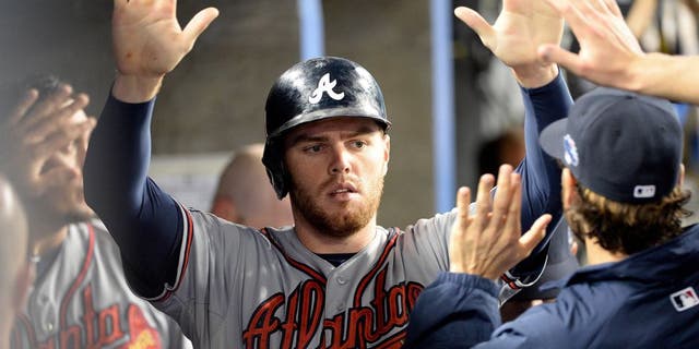 October 7, 2013; Los Angeles, CA, USA; Atlanta Braves first baseman Freddie Freeman (5) celebrates after he scores a run in the fourth inning against the Los Angeles Dodgers in game four of the National League divisional series playoff baseball game at Dodger Stadium. Mandatory Credit: Richard Mackson-USA TODAY Sports