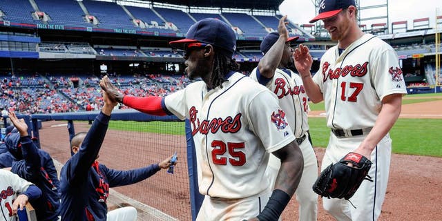Atlanta Braves center fielder Cameron Maybin (25) is followed by pitcher Shelby Miller (17) as he is congratulated while entering the dugout after catching a fly ball hit by St. Louis Cardinals' Brandon Moss and throwing out Greg Garcia at first to turn a double play during the fourth inning of the first baseball game of a doubleheader, Sunday, Oct. 4, 2015, in Atlanta. (AP Photo/John Amis)