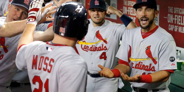 St. Louis Cardinals' Brandon Moss (21) celebrates his two-run home run against the Arizona Diamondbacks with teammates Matt Carpenter, right, and Yadier Molina (4) during the fifth inning of a baseball game Wednesday, Aug. 27, 2015, in Phoenix. (AP Photo/Ross D. Franklin)