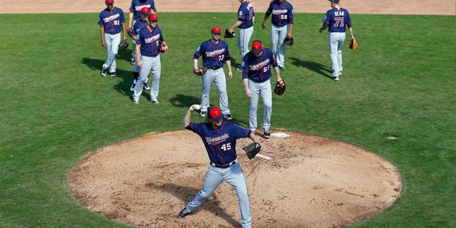 Minnesota Twins pitcher Phil Hughes runs a drill as teammates watch during a spring training baseball workout in Fort Myers, Fla., Monday, Feb. 22, 2016.