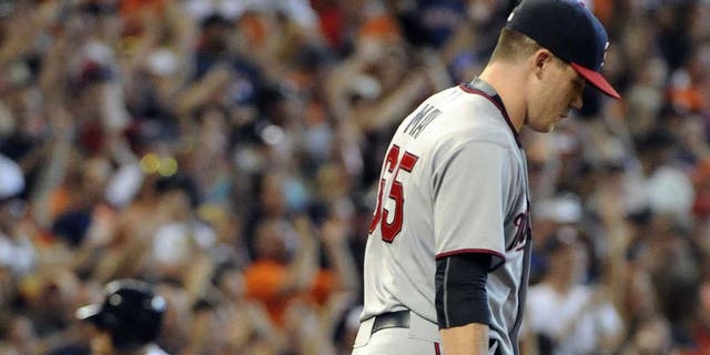 Minnesota Twins relief pitcher Trevor May walks back to the mound as Jed Lowrie rounds third base after hitting a grand slam in the seventh inning Sunday, Sept. 6, 2015, in Houston.