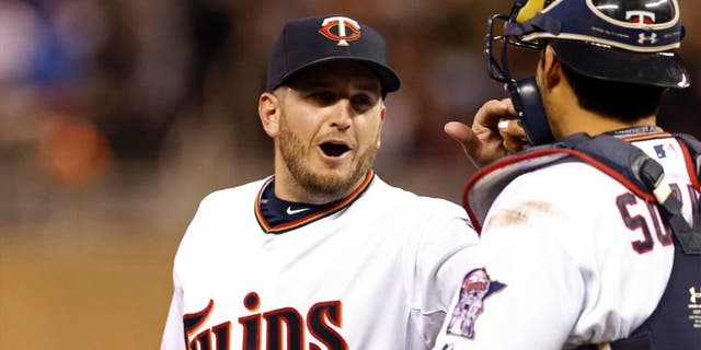 Minnesota Twins pitcher Glen Perkins (left) and catcher Kurt Suzuki celebrate the Twins' 8-7 win over the Oakland Athletics on Monday, May 4, 2015, in Minneapolis.