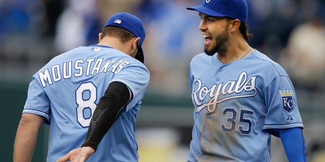 Kansas City Royals first baseman Eric Hosmer (35) and third baseman Mike Moustakas (8) celebrate following a baseball game against the Chicago White Sox at Kauffman Stadium in Kansas City, Mo., Thursday, April 9, 2015. The Royals defeated the White Sox 4-1. (AP Photo/Orlin Wagner)