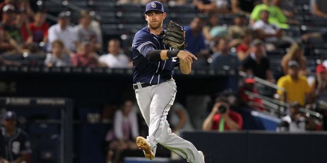 San Diego Padres third baseman Will Middlebrooks (11) throws a runner out at first base against the Atlanta Braves in the tenth inning at Turner Field.
