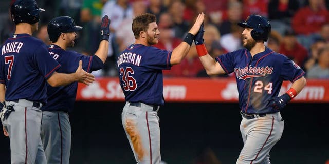 The Minnesota Twins' Trevor Plouffe (right) is congratulated by Joe Mauer (left), Brian Dozier (second from left) and Robbie Grossman after hitting a three-run home run during the third inning against the Los Angeles Angels on Monday, June 13, 2016, in Anaheim, Calif.