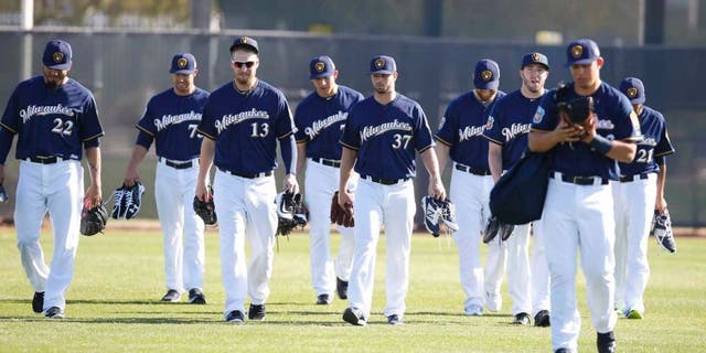 Milwaukee Brewers pitchers and catchers walk on the field during spring training camp at Maryvale Baseball Park in Maryvale, Ariz., on Sunday, Feb. 21, 2016.