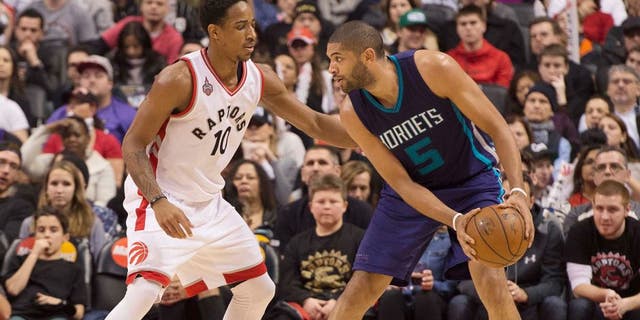 Jan 1, 2016; Toronto, Ontario, CAN;Charlotte Hornets guard Nicolas Batum (5) looks to play a ball as Toronto Raptors guard DeMar DeRozan (10) tries to defend during the third quarter in a game at Air Canada Centre. The Toronto Raptors won 104-94. Mandatory Credit: Nick Turchiaro-USA TODAY Sports