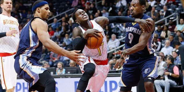 Atlanta Hawks guard Dennis Schroder (17) drives between Memphis Grizzlies' Jarnell Stokes (1) and Tony Allen (9) in the first half of an NBA basketball game Wednesday, Oct. 21, 2015, in Atlanta. (AP Photo/John Bazemore)