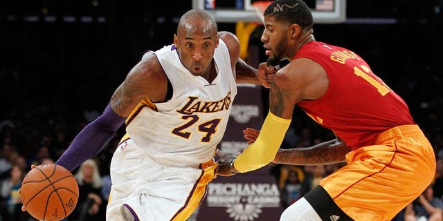 Los Angeles Lakers forward Kobe Bryant (24) drives against Indiana Pacers forward Paul George, right, during the first half of an NBA basketball game in Los Angeles, Sunday, Nov. 29, 2015. (AP Photo/Alex Gallardo)