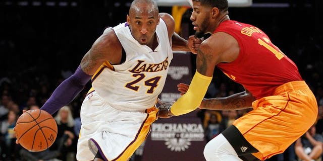 Los Angeles Lakers forward Kobe Bryant (24) drives against Indiana Pacers forward Paul George, right, during the first half of an NBA basketball game in Los Angeles, Sunday, Nov. 29, 2015. (AP Photo/Alex Gallardo)