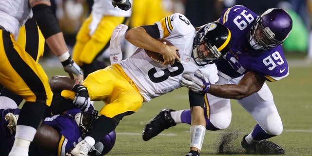 Pittsburgh Steelers quarterback Landry Jones is tackled by Minnesota Vikings defensive end Danielle Hunter (right) and defensive tackle Shamar Stephen (bottom left) after scrambling for a short gain during the second half of an NFL preseason football game in Canton, Ohio, on Sunday, August 9, 2015.