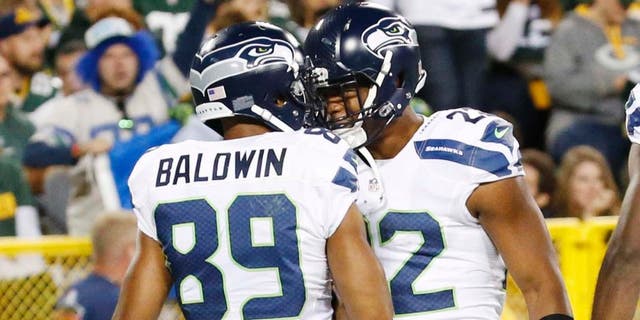 The Seattle Seahawks' Doug Baldwin celebrates his touchdown catch with Fred Jackson during the second half of an NFL football game against the Green Bay Packers on Sunday, Sept. 20, 2015, in Green Bay, Wis.