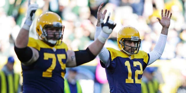 Green Bay Packers quarterback Aaron Rodgers (right) and Bryan Bulaga signal a touchdown after Rodgers threw a five-yard touchdown pass to James Starks during the first half against the San Diego Chargers on Sunday, Oct. 18, 2015, in Green Bay, Wis.