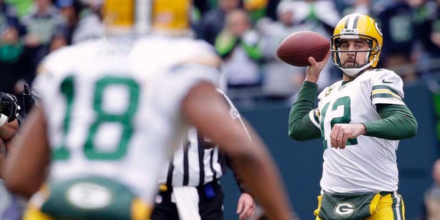 The Green Bay Packers' Aaron Rodgers (right) looks to pass to Randall Cobb during the first half of the NFC championship game in Seattle.