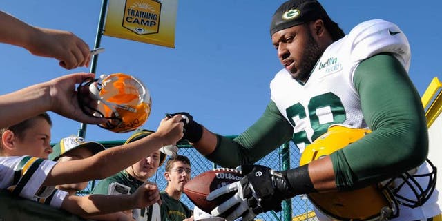 Green Bay Packers tackle Fabbians Ebbele signs autographs for fans during training camp on Aug. 3, 2015, at Ray Nitschke Field.