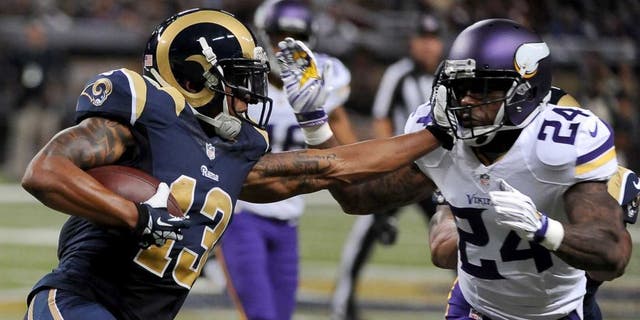 St. Louis Rams wide receiver Chris Givens (left) runs with the ball for a 4-yard gain before being stopped by Minnesota Vikings cornerback Captain Munnerlyn during the second quarter in St. Louis. Munnerlyn was also given a 15-yard unnecessary roughness penalty on the play.