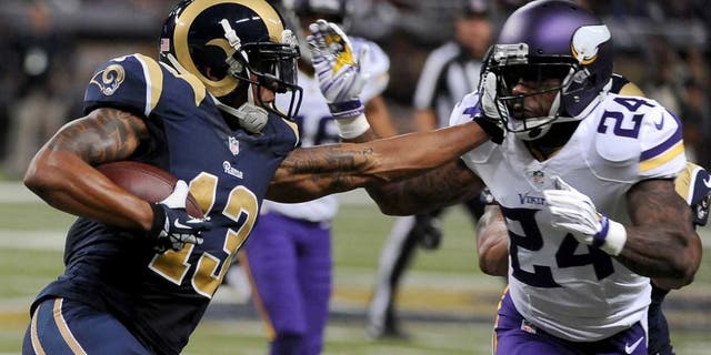 St. Louis Rams wide receiver Chris Givens (left) runs with the ball for a 4-yard gain before being stopped by Minnesota Vikings cornerback Captain Munnerlyn during the second quarter in St. Louis. Munnerlyn was also given a 15-yard unnecessary roughness penalty on the play.