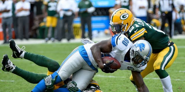 Detroit Lions wide receiver Anquan Boldin is tackled by Green Bay Packers defensive back Micah Hyde and safety Ha Ha Clinton-Dix.