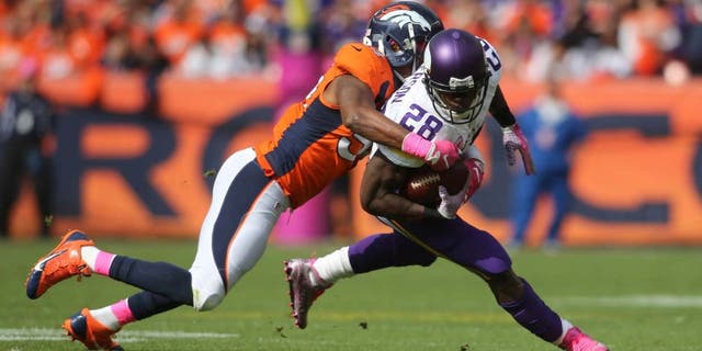 Minnesota Vikings running back Adrian Peterson is taken down by Denver Broncos inside linebacker Brandon Marshall during the first half at Sports Authority Field at Mile High in Denver on Sunday, Oct. 4, 2015.