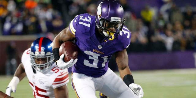 Minnesota Vikings running back Jerick McKinnon jumps over New York Giants defenders during the first half Sunday, Dec. 27, 2015, in Minneapolis.