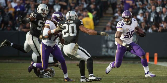 Minnesota Vikings running back Adrian Peterson runs with the football against Oakland Raiders strong safety Nate Allen during the fourth quarter at O.co Coliseum in Oakland, Calif., on Sunday, Nov. 15, 2015.