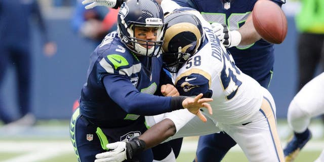 Dec 29, 2013; Seattle, WA, USA; Seattle Seahawks quarterback Russell Wilson (3) throws the ball as St. Louis Rams outside linebacker Jo-Lonn Dunbar (58) tackles during the first half at CenturyLink Field. Mandatory Credit: Steven Bisig-USA TODAY Sports