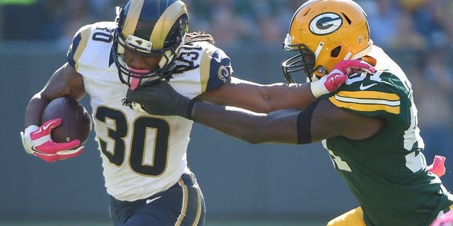 Oct 11, 2015; Green Bay, WI, USA; St. Louis Rams running back Todd Gurley (30) pushes away Green Bay Packers linebacker Nate Palmer (51) in the third quarter at Lambeau Field. Mandatory Credit: Benny Sieu-USA TODAY Sports