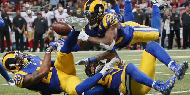 St. Louis Rams' Rodney McLeod, cornerback Trumaine Johnson (22) and linebacker James Laurinaitis converge on a pass but are unable to make an interception during an NFL football game against the San Francisco 49ers Sunday, Nov. 1, 2015, in St. Louis. (Chris Lee/St. Louis Post-Dispatch via AP) EDWARDSVILLE INTELLIGENCER OUT; THE ALTON TELEGRAPH OUT; MANDATORY CREDIT