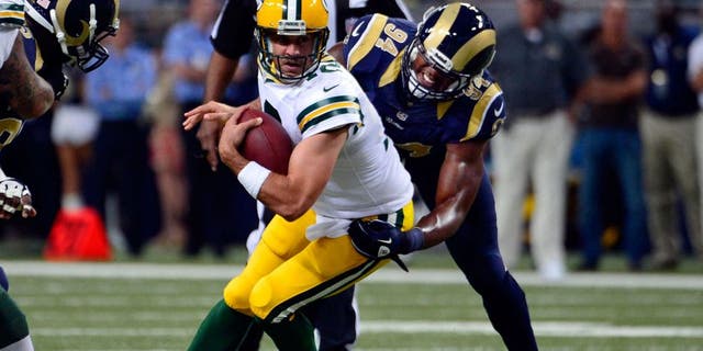 Aug 17, 2013; St. Louis, MO, USA; St. Louis Rams defensive end Robert Quinn (94) sacks Green Bay Packers quarterback Aaron Rodgers (12) during the first half at the Edward Jones Dome. Mandatory Credit: Scott Rovak-USA TODAY Sports