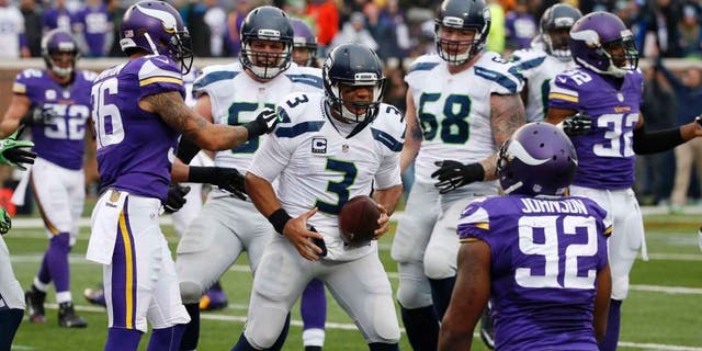 Seattle Seahawks quarterback Russell Wilson celebrates his 8-yard touchdown run against the Minnesota Vikings in the first half of an NFL football game Sunday, Dec. 6, 2015, in Minneapolis.