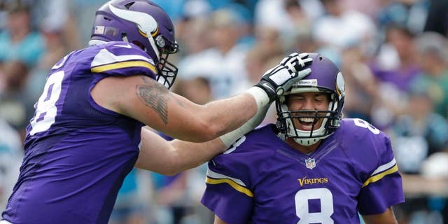 The Minnesota Vikings' Sam Bradford (right) is congratulated by Jeremiah Sirles after touchdown pass against the Carolina Panthers in the second half in Charlotte, N.C., Sunday, Sept. 25, 2016.