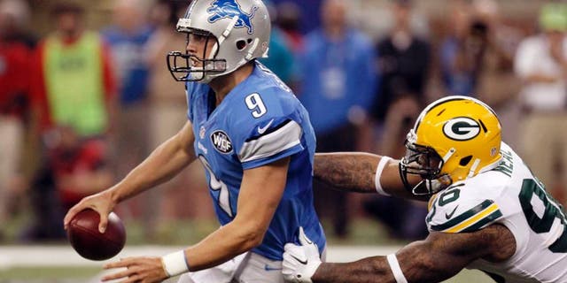 Green Bay Packers outside linebacker Mike Neal (right) reaches in on Detroit Lions quarterback Matthew Stafford during the first half.