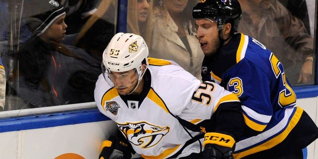 Nashville Predators' Roman Josi (59), of Switzerland, reaches for the puck with St. Louis Blues' Jordan Caron (33) during the first period of an NHL hockey game, Tuesday, Dec. 29, 2015, in St. Louis. The Blues won in overtime 4-3. (AP Photo/Bill Boyce)