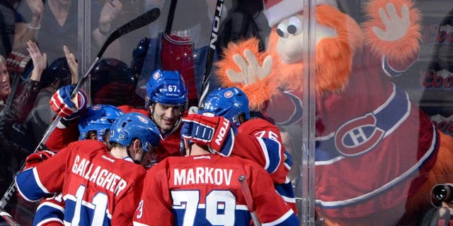 Dec 17, 2013; Montreal, Quebec, CAN; Montreal Canadiens forward Max Pacioretty (67) celebrates with teammates Brendan Gallagher (11) and P.K. Subban (76) and Andrei Markov (79) with team mascot Youppi in the background after scoring a goal against the Phoenix Coyotes during the third period at the Bell Centre. Mandatory Credit: Eric Bolte-USA TODAY Sports