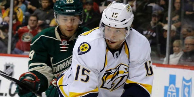 Nashville Predators center Craig Smith (right) controls the puck in front of Minnesota Wild right wing Jason Pominville during the second period.