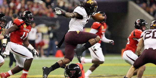 Dec 28, 2012; Houston, TX, USA; Minnesota Golden Gophers defensive back Troy Stoudermire (2) leaps over a defender on a kickoff return against the Texas Tech Red Raiders during the first quarter of the Car Care Bowl at Reliant Stadium. Mandatory Credit: Troy Taormina-USA TODAY Sports