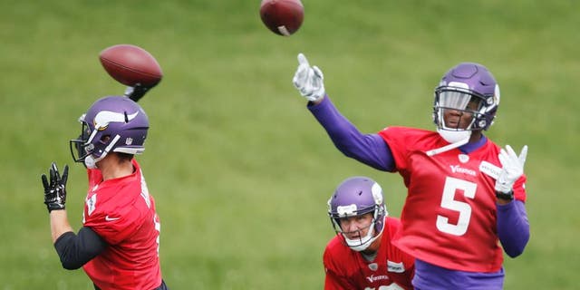 CORRECTS YEAR -Minnesota Vikings quarterbacks Teddy Bridgewater, right, and Taylor Heinicke throw during the NFL football team's minicamp Wednesday, June 15, 2016, in Eden Prairie, Minn. Watching, bottom center, is quarterback Shaun Hill. (AP Photo/Jim Mone)