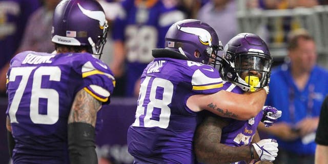 Minnesota Vikings running back Jerick McKinnon, right, celebrates with teammates Zach Line, center, and Alex Boone, left, after scoring on a 4-yard touchdown run during the second half of an NFL football game against the New York Giants, Monday, Oct. 3, 2016, in Minneapolis. (AP Photo/Andy Clayton-King)