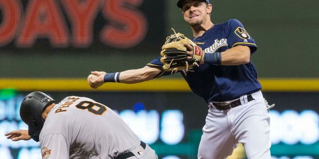 Milwaukee Brewers' Scooter Gennett throws to first after forciong out San Fransisco Giants' Hunter Pence during the fourth inning of a baseball game Tuesday, April 5, 2016, in Milwaukee. Matt Duffy was safe at first, and an run scored. (AP Photo/Tom Lynn)
