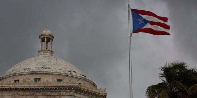 SAN JUAN, PUERTO RICO - JULY 01: The Puerto Rican flag flies near the Capitol building as the island's residents deal with the government's $72 billion debt on July 1, 2015 in San Juan, Puerto Rico. Governor of Puerto Rico Alejandro Garc?a Padilla said in a speech recently that the people of Puerto Rico will have to make sacrifices and share the responsibilities to help pull the island out of debt. (Photo by Joe Raedle/Getty Images)