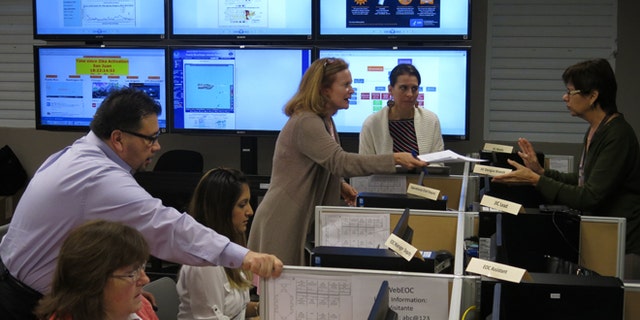 FILE - In this Feb. 24, 2016 file photo, workers from the Puerto Rico Health Department and the Centers for Disease Control and Prevention review Zika-related data collected by the island's health department and the CDC in San Juan, Puerto Rico. On Friday, June 17, 2016, Dr. Tom Frieden, the director of the CDC, is warning that dozens or hundreds of babies in Puerto Rico could develop severe birth defects because of the virus, based on how an outbreak is playing out there. (AP Photo/Danica Coto)